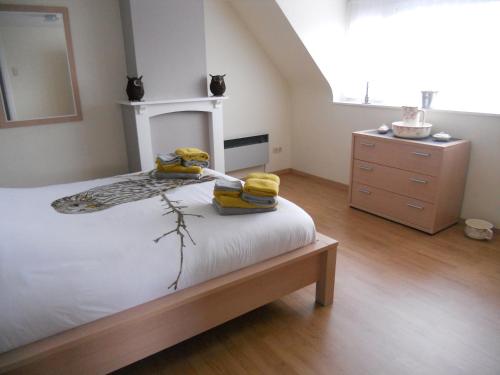 a bedroom with a bed and a dresser at Het Margrietje in Merkem