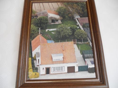 a picture of a house in a frame on a wall at Het Margrietje in Merkem