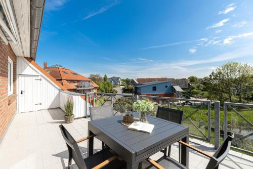 a patio with a table and chairs on a balcony at Haus Baltic Flat White in Laboe