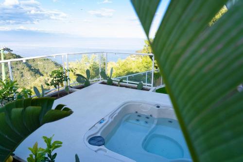a hot tub on a balcony with a palm tree at Villa Zagara Garden Spectacular Sea View in Taormina in Taormina