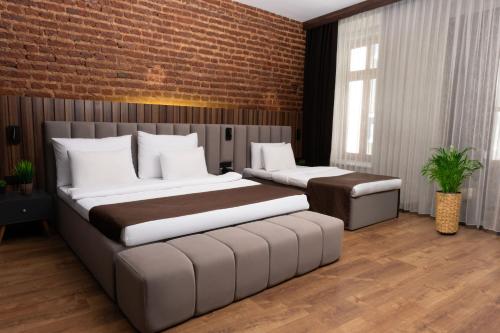 a bedroom with two beds and a brick wall at Vita Suites Karaköy in Istanbul