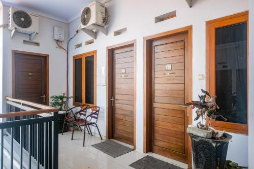 a hallway with two wooden doors and a balcony at RedDoorz @ Jalan Kedawung in Malang