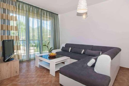 a living room with a couch and a tv at Villa Angel in Kamenari
