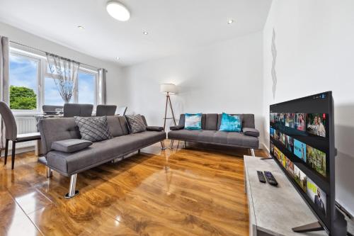 a living room with a couch and a tv at Bright 4BR 2BA Gem in Wembley Harrow - Sleeps 8 in Kenton