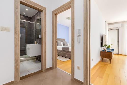 a bedroom with a bed and a mirror at Apart hotel M S KATUNJANIN in Herceg-Novi