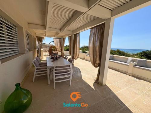 a dining room with a table and chairs on a patio at Stanze VILLA DEL CONTE a Punta Prosciutto by SalentoGo in Punta Prosciutto