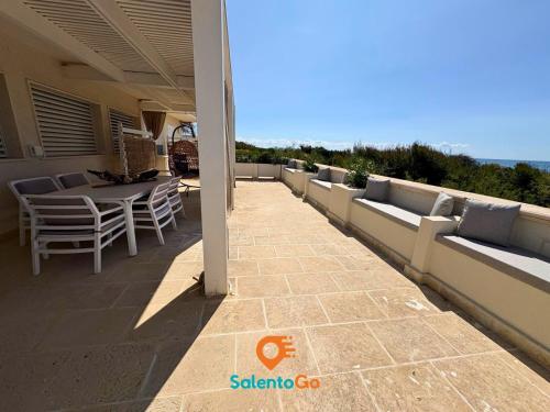 a patio with a table and chairs on a balcony at Stanze VILLA DEL CONTE a Punta Prosciutto by SalentoGo in Punta Prosciutto