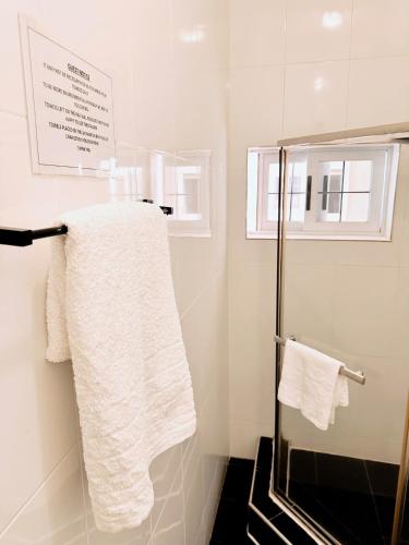 a bathroom with white towels on a towel rack at Golden Crystal Hotel in Accra