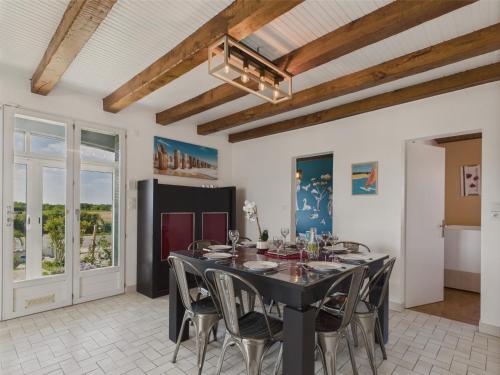 une salle à manger avec une table et des chaises noires dans l'établissement Maison pour 2 adultes et 2 enfants avec jardin, à Le Bernard