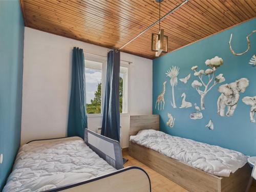 Le BernardにあるMaison pour 2 adultes et 2 enfants avec jardinの青い壁のベッドルーム1室(ベッド1台付)