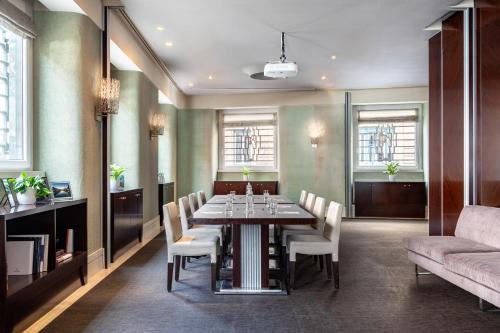 a dining room with a table and chairs and a couch at Meliá Genova in Genova
