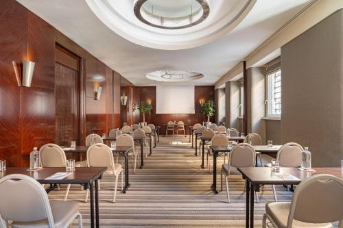 a dining room with tables and chairs and a ceiling at Meliá Genova in Genova