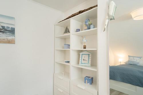 a bedroom with white shelves and a bed at Zur lachenden Möwe in Grömitz