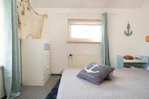 a bedroom with a bed with a pillow on it at Zur lachenden Möwe in Grömitz