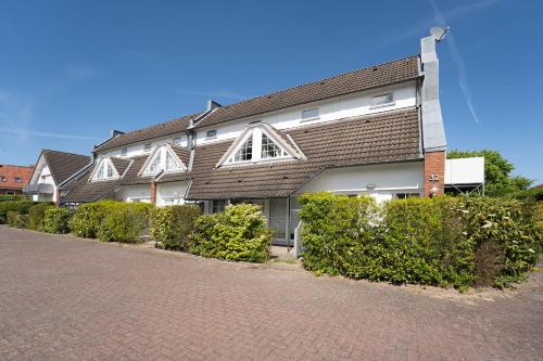 a large house on a brick road with bushes at Zur lachenden Möwe in Grömitz