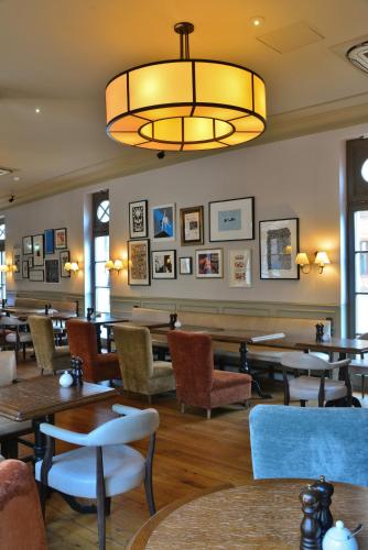 a restaurant with tables and chairs and a chandelier at Monbijou Hotel in Berlin