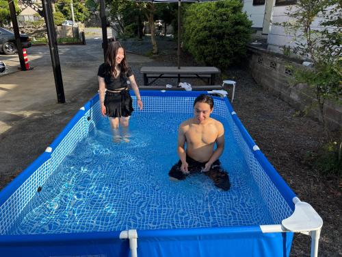 a man and a woman standing in a swimming pool at 一棟貸しの宿 貸別荘 水戸ハウス Vacation Rental Mito House! Location is 1-2-55 Kanemachi Ibaraki Prefecture 場所は茨城県水戸市金町1-2-55です ドア横のキーボックスの番号はご予約後に,チェックイン情報を見る,をご覧下さい in Mito