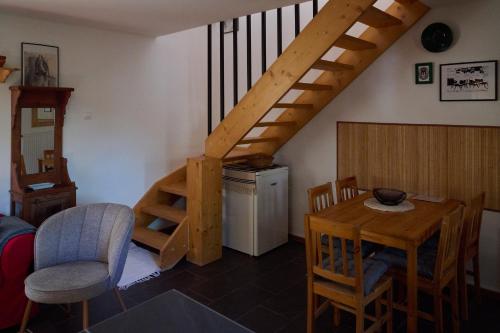 a living room with a staircase and a table and chairs at Kőris Tanya in Hódmezővásárhely