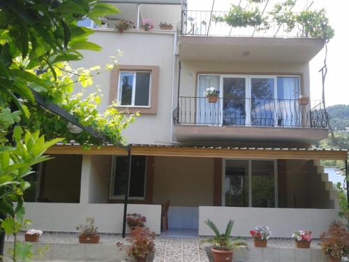 a large white house with a balcony and plants at Rose Apart in Sarigerme