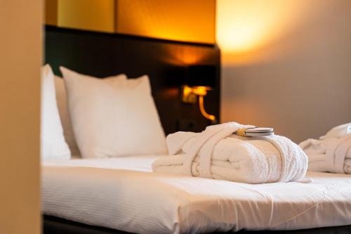 a hotel room with a bed with towels on it at Leonardo Oranje Hotel Leeuwarden in Leeuwarden