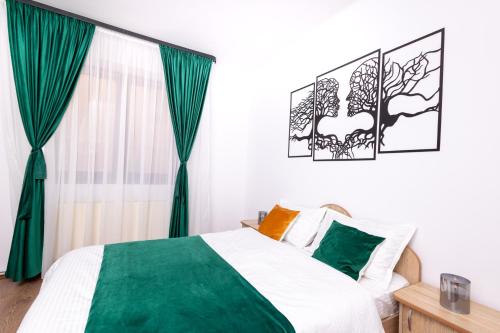 a bedroom with a green and white bed and a window at Casa Walter Ultracentral - Terasă Privată in Curtea de Argeş