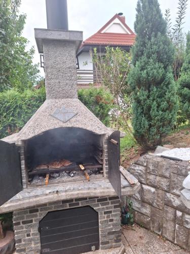 an outdoor pizza oven in a yard at Studio Vista apartment in Leskovec pri Krškem