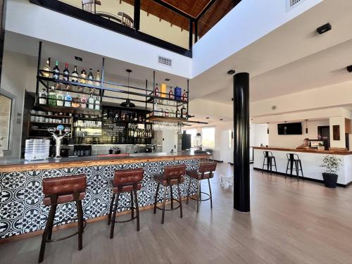a bar in a restaurant with stools at Pie de Piedra Hotel Boutique in Sierra de la Ventana
