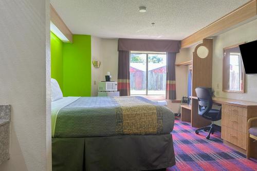 a hotel room with a bed and a desk at Classic Inn By Townhouse American Way Memphis I 240 in Memphis