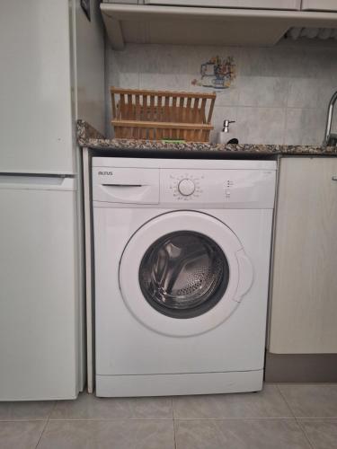a white washing machine in a kitchen with a counter at Piso California 3 aire acondicionado, wifi, cerca del mar in Miami Platja