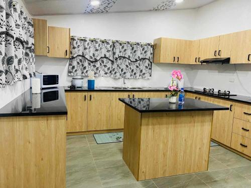 a kitchen with wooden cabinets and a black counter top at Navo Home Stay in Nadi