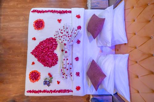 a table topped with white napkins with flowers on it at Hill River Resort - Central Heated & Air Cooled - Near Mall Road , Best Property of Manali 2024- 2025 in Manāli