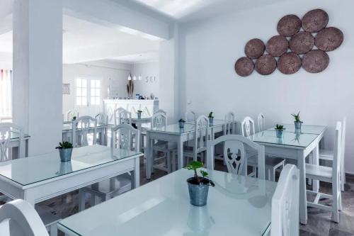 a white dining room with white tables and white chairs at Selini Ηotel in Kamari