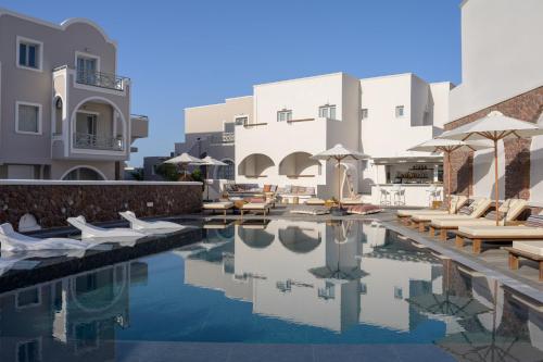 a pool at a hotel with chairs and umbrellas at Selini Ηotel in Kamari