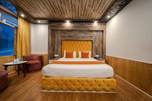a bedroom with a large bed with a wooden ceiling at Hill River Resort - Central Heated & Air Cooled - Near Mall Road , Best Property of Manali 2024- 2025 in Manāli