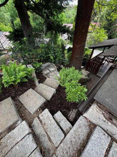 a garden with a stone walkway next to a tree at Chaloupka ve skalách u rybníka na úchvatné stezce z Kutné Hory do historického Malešova in Miskovice