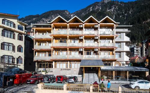 a large building with cars parked in front of it at Hill River Resort - Central Heated & Air Cooled - Near Mall Road , Best Property of Manali 2024- 2025 in Manāli