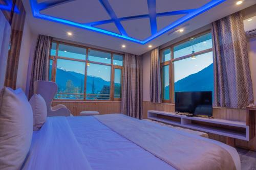a bedroom with a large bed and a television at Hill River Resort - Central Heated & Air Cooled - Near Mall Road , Best Property of Manali 2024- 2025 in Manāli