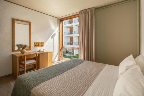 a hotel room with a bed and a window at Amalia Hotel Delphi in Delfoi