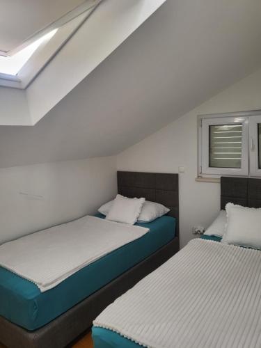 Beach Spot Apartments في ماكارسكا: سريرين في غرفة صغيرة بها نافذة