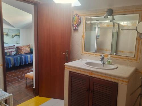 a bathroom with a sink and a mirror at CASA MILFONTES by Stay in Alentejo in Vila Nova de Milfontes