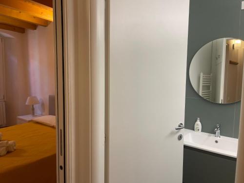 Un baño con un lavabo y un espejo en la pared. en Piccolo Duomo, en Saló