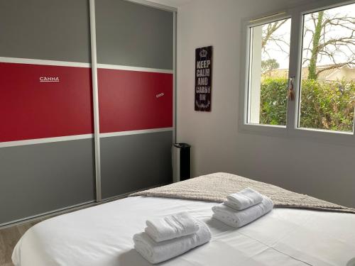 une chambre avec un lit avec deux serviettes dessus dans l'établissement Superbe Villa Bassin Arcachon - Piscine Chauffée, à Gujan-Mestras