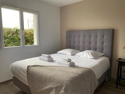 une chambre avec un grand lit avec des serviettes dessus dans l'établissement Superbe Villa Bassin Arcachon - Piscine Chauffée, à Gujan-Mestras