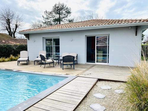 une maison avec une terrasse et une piscine dans l'établissement Superbe Villa Bassin Arcachon - Piscine Chauffée, à Gujan-Mestras