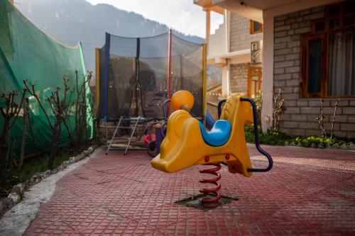 a playground with a plastic chair on a brick ground at Hill River Resort - Central Heated & Air Cooled - Near Mall Road , Best Property of Manali 2024- 2025 in Manāli