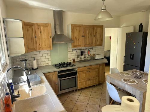 une cuisine avec un évier et une cuisinière four supérieur dans l'établissement Maison au calme, nature et paix, à Trélissac