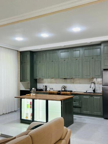 a kitchen with green cabinets and a kitchen island at Gabala Breeze Villa in Gabala