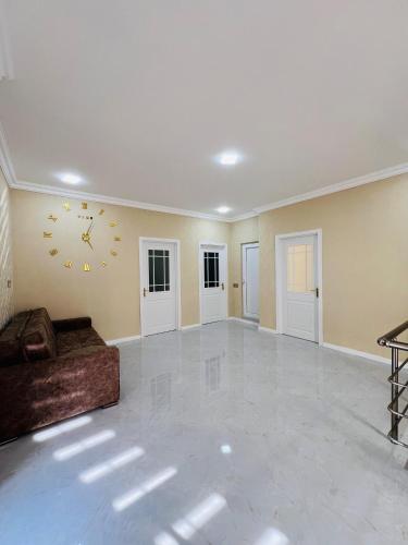 a living room with a couch and a clock on the wall at Gabala Breeze Villa in Gabala