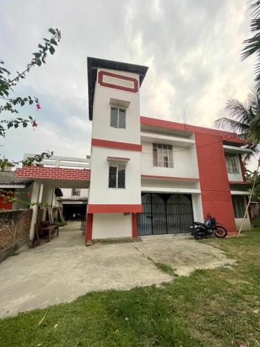 a house with a red and white building at Notel Stays in Jorhāt