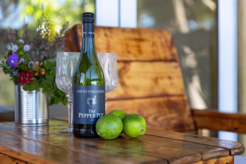 a bottle of wine and some apples on a table at Kyles Forest Cabin in Kafferkop
